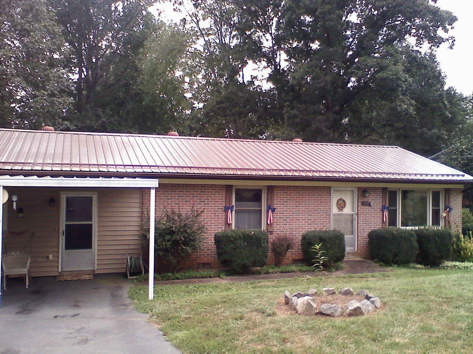 Bronze metal roof and carport on a brick ranch home — Roof Repair work by our crew in Bayonne